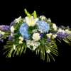 Blue hydrangeas and white lilies in a low floral arrangement