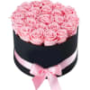 Pink roses arranged in a black round box with a pink ribbon bow