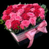 Pink and red roses in a black gift box with a pink ribbon