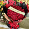 Large bouquet of red roses wrapped in black and red paper with a birthday ribbon