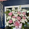 Pink roses and white daisies in a white basket with a pink ribbon