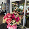 Pink and cream mixed flower arrangement in a white hat box with a pink ribbon