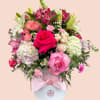 Pink and white mixed flower arrangement in a round box with a satin ribbon