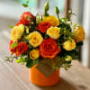 This bold and cheerful arrangement is filled with orange and yellow florals