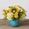 Yellow and white flower arrangement in a blue vase