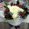 Bouquet of white roses, red carnations, and dark red flowers in clear wrap