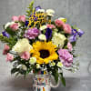 Birthday bouquet in a mug with sunflowers, roses, and mixed blooms