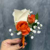 White calla lily boutonniere with orange roses and baby's breath