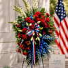 Red, white, and blue floral standing spray with ribbon bow and memorial sign