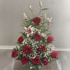 Red roses and white lilies arranged in a clear glass vase