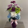 Mixed bouquet in a purple vase with a pink ribbon