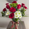 Bouquet of red roses and white daisies in a glass vase
