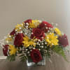 Red roses and yellow daisies in a clear square vase