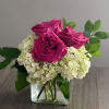 Pink roses with white hydrangeas in a clear glass vase