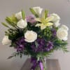 White roses and lilies with purple flowers in a glass vase