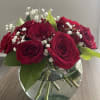 Red roses in a clear glass vase with white baby's breath