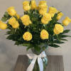 Yellow roses in a glass vase tied with a white ribbon