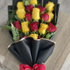 Bouquet of red and yellow roses wrapped in black paper with a red bow