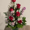 Red roses and white bellflowers in a clear glass vase