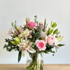 Pink roses and white lilies in a clear glass vase