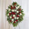 Standing funeral spray with red roses, white lilies, and white pompons