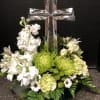 White and green floral arrangement with a glass cross centerpiece