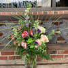 Mixed bouquet in a clear glass vase with pink, purple, and green flowers