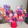 Colorful bouquet in a pink vase with pink, purple, and coral flowers