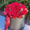 Red rose bouquet in a black hat box with a pink ribbon