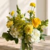 Yellow and white floral arrangement in a clear glass vase