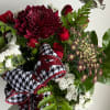 Bouquet of red and white flowers with a black-and-white ribbon bow