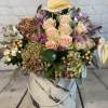 Mixed bouquet of pale pink roses and hydrangeas in a marble-patterned hat box