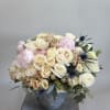 Roses in any color with seasonal peonies arranged in a ceramic vase