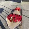 Bouquet of red roses wrapped in tan paper with a red ribbon