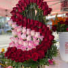 Tiered arrangement of red and pink roses in a gold vase