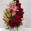 Red roses and pink lilies arranged in a white vase