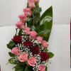 Tall arrangement of pink and red roses in a black vase
