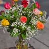 Mixed roses in a clear glass vase with baby's breath