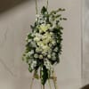 Tall white floral standing arrangement on an easel