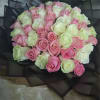 Bouquet of pink and white roses wrapped in black paper