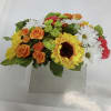 Mixed bouquet with sunflowers, orange roses, white daisies, and pink carnations in a box
