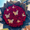 Round bouquet of red roses with decorative butterfly accents.