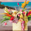 Tropical flower arrangement in a woven basket with pink and orange blooms