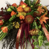 Large spray of orange roses and mixed autumn flowers with ribbons