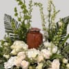 White roses and tulips arranged around a wooden urn
