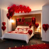 Bedroom decorated with red heart balloons, rose petals, and candles
