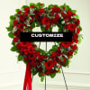 Heart-shaped red floral wreath on a stand with a ribbon bow