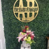 Pink lilies and roses arranged in a white vase on a pedestal