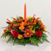 Autumn floral centerpiece with a tall orange taper candle