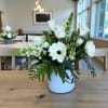 White roses and gerbera daisies arranged in a white vase